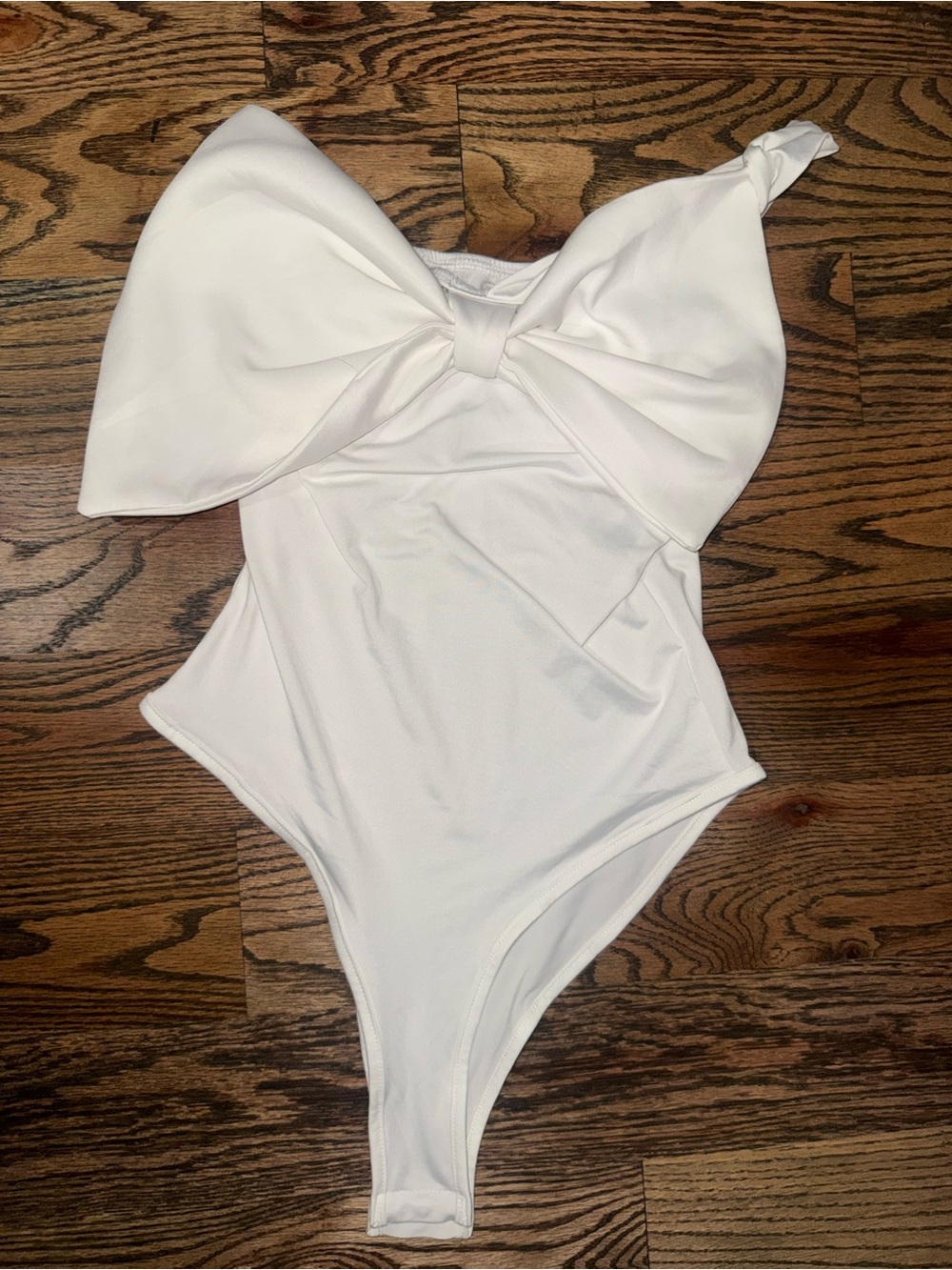 White bodysuit with bow.